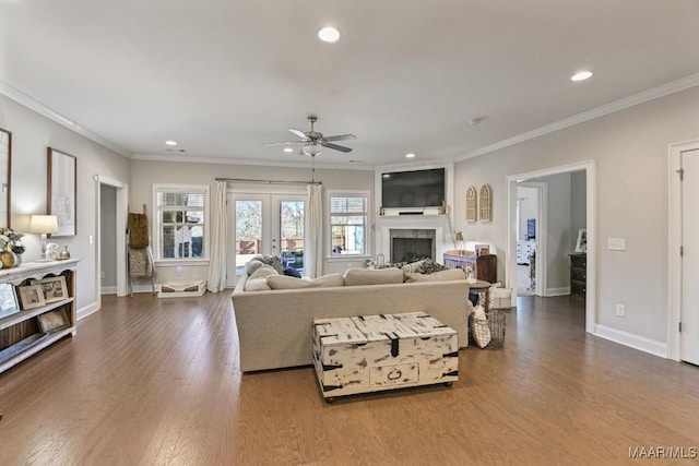 living room with ornamental molding, recessed lighting, baseboards, and wood finished floors