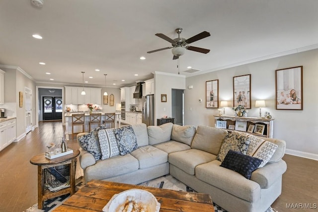 living area featuring light wood finished floors, baseboards, crown molding, and recessed lighting