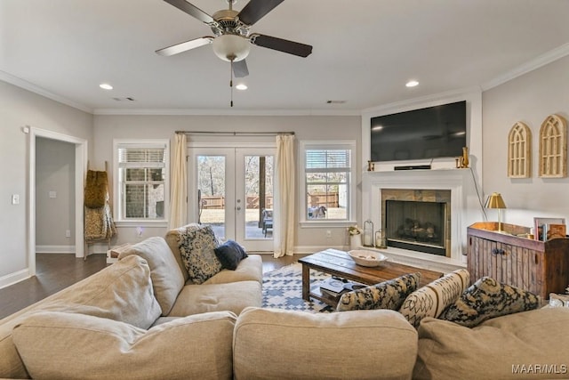 living area with baseboards, ornamental molding, and wood finished floors