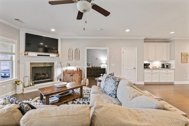 living area with baseboards, dark wood-style flooring, a fireplace, and crown molding