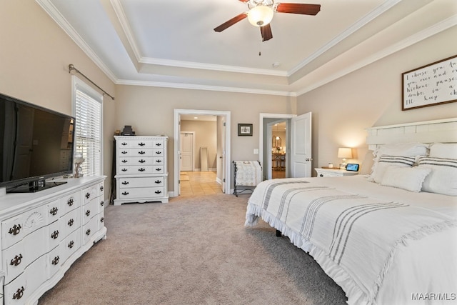 bedroom featuring a tray ceiling, light carpet, crown molding, and ceiling fan