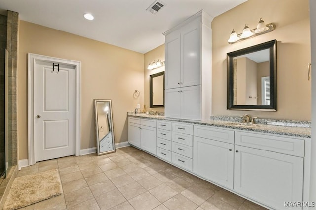 full bathroom featuring double vanity, baseboards, visible vents, and a sink