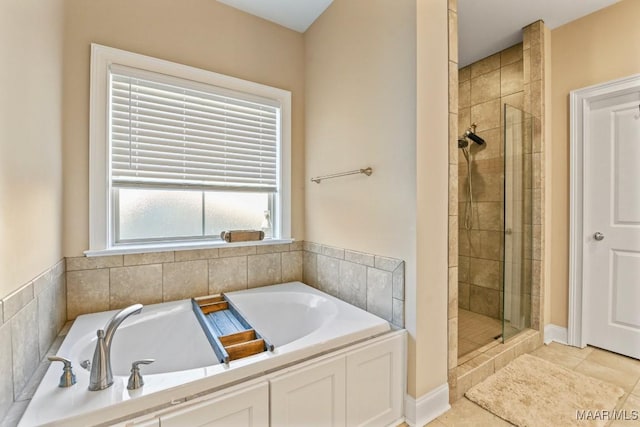 full bath with a stall shower, tile patterned flooring, and a bath