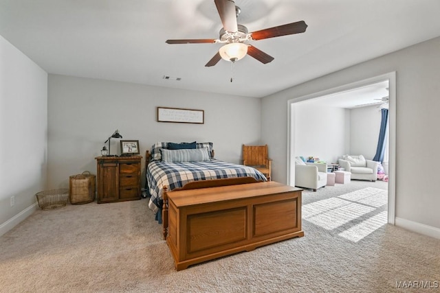 bedroom with light carpet, a ceiling fan, visible vents, and baseboards