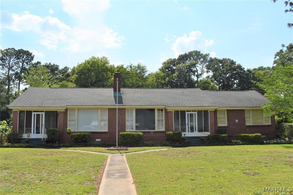 ranch-style home with a front lawn and brick siding