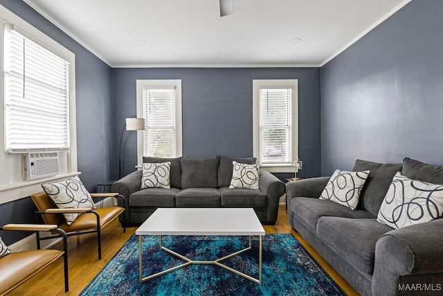 living area featuring crown molding, cooling unit, and wood finished floors