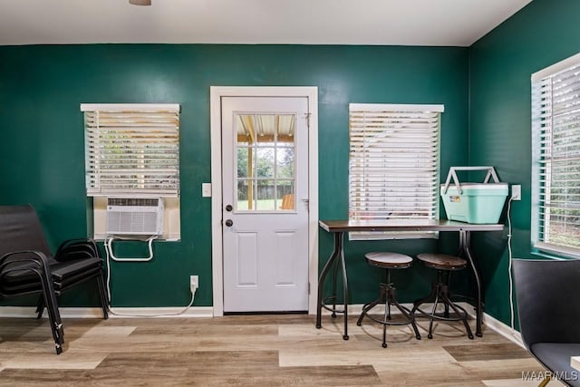 interior space with light wood-type flooring, baseboards, and cooling unit