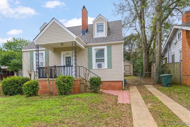 view of front of property featuring a shingled roof, a chimney, a front yard, and fence