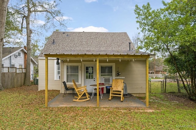 back of house with fence private yard, a shingled roof, a patio area, and a yard