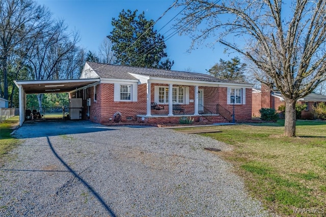 view of front of home with aphalt driveway, covered porch, brick siding, a carport, and a front lawn