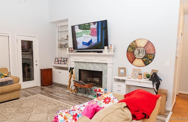 living area with a tiled fireplace and light wood-style floors