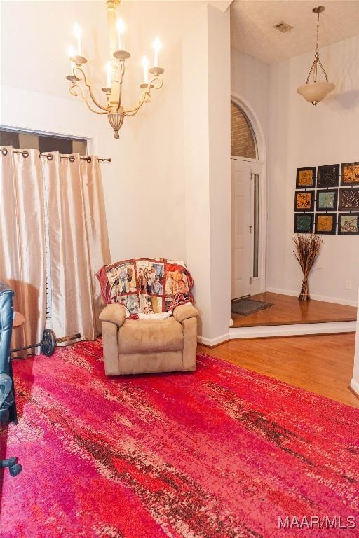 interior space featuring an inviting chandelier, baseboards, and wood finished floors