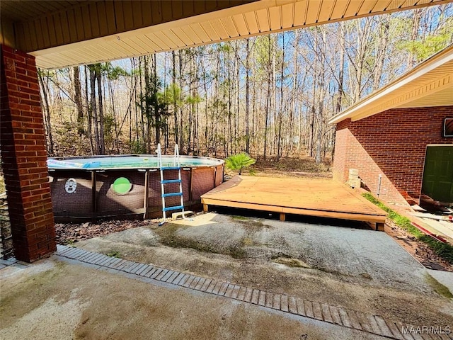 view of patio with a wooden deck and an outdoor pool