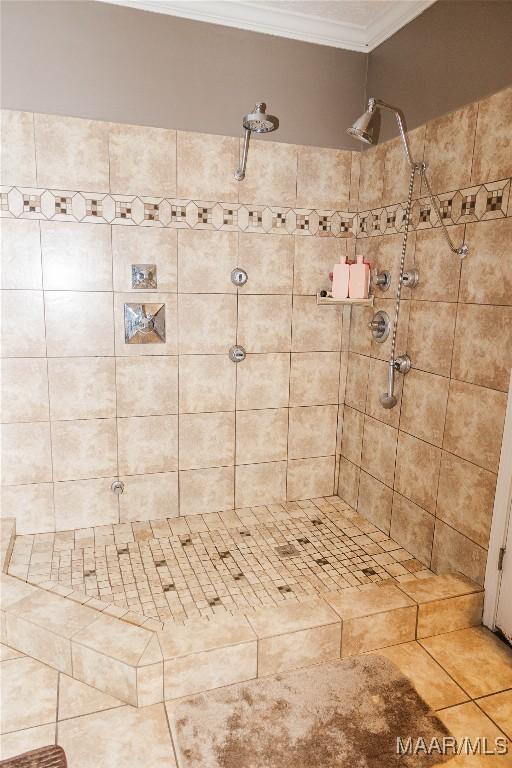 full bathroom featuring ornamental molding, a tile shower, and tile patterned floors