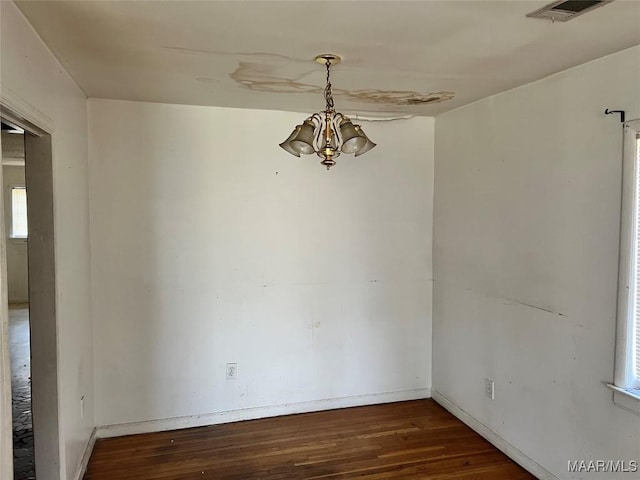 unfurnished room featuring a chandelier, dark wood-style flooring, visible vents, and baseboards