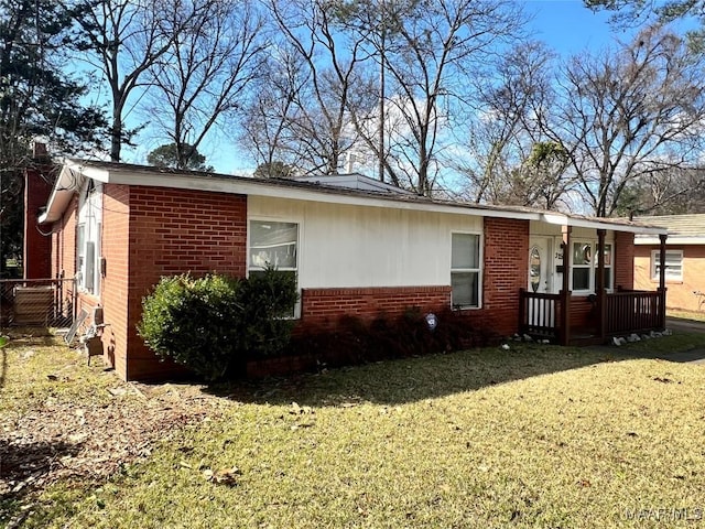 view of side of home with a yard and brick siding