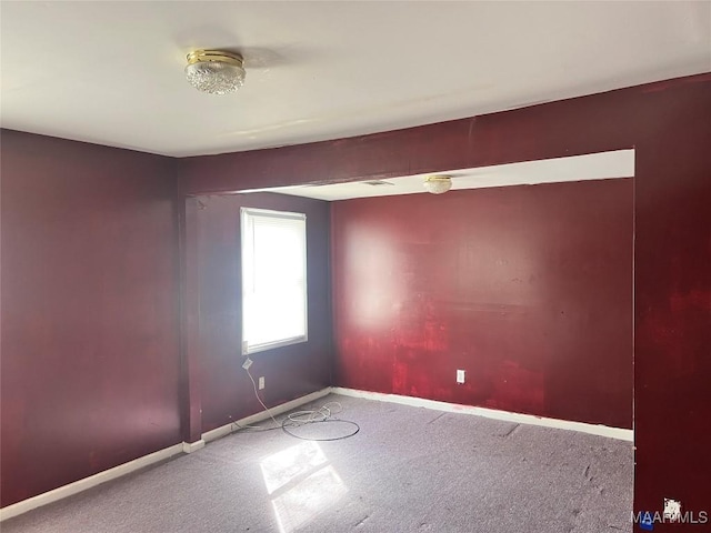 carpeted empty room with baseboards