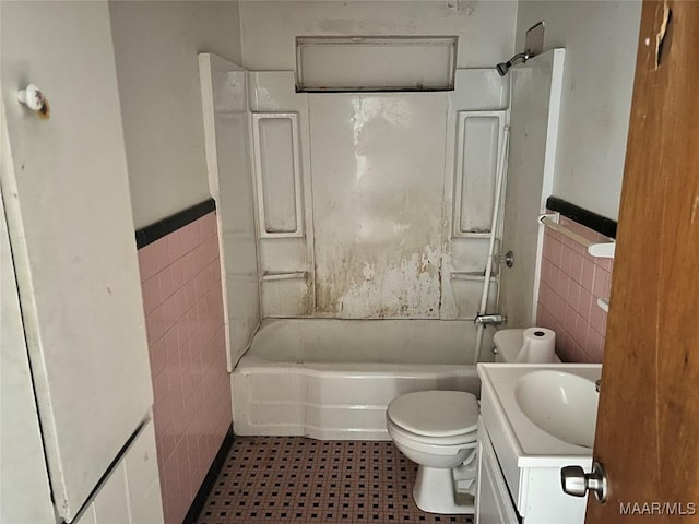 full bath featuring tub / shower combination, toilet, tile walls, and vanity