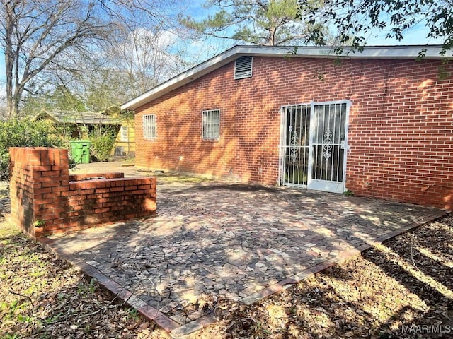 back of property featuring a patio area and brick siding