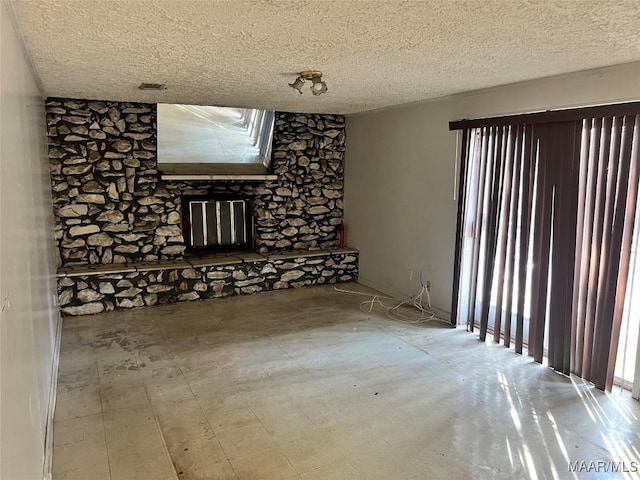 spare room featuring a textured ceiling and tile patterned floors