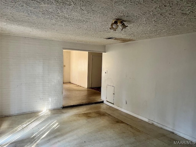 empty room featuring a textured ceiling and visible vents