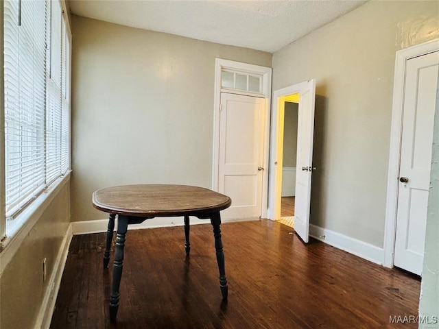 dining space with dark wood-style floors and baseboards