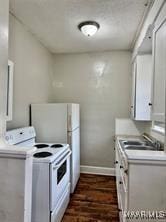 kitchen with white appliances, light countertops, baseboards, and white cabinets