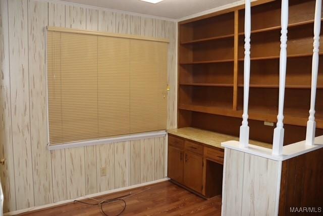 unfurnished office with dark wood-style flooring and wooden walls