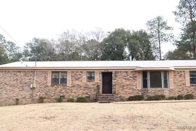 ranch-style home with entry steps and brick siding