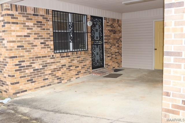 view of exterior entry featuring brick siding