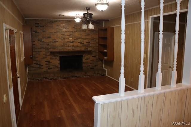 unfurnished living room featuring ceiling fan, a fireplace, and wood finished floors