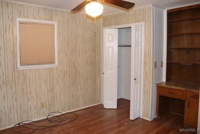 unfurnished bedroom with a ceiling fan and dark wood-type flooring