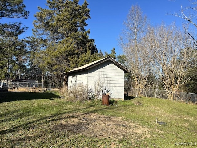 view of side of home with an outbuilding, a storage shed, a lawn, and fence