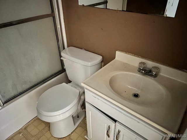 bathroom featuring toilet, shower / bath combination with glass door, tile patterned floors, and vanity