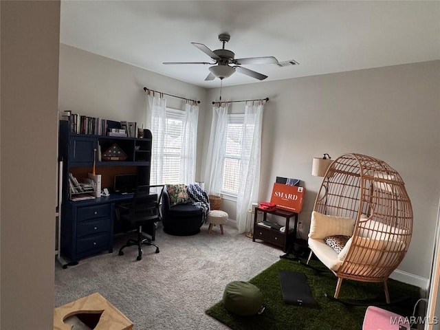 office space featuring baseboards, visible vents, a ceiling fan, and light colored carpet