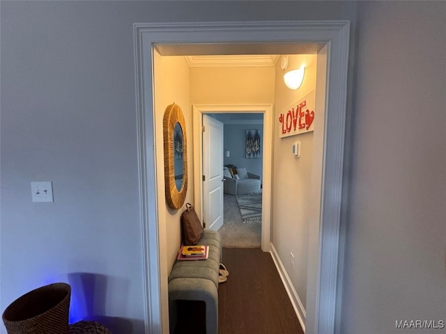 corridor with dark wood-style flooring, crown molding, and baseboards