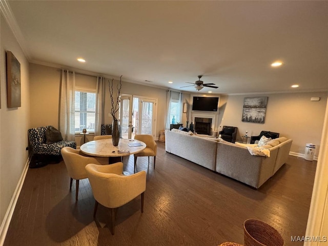 dining area with dark wood-style floors, ornamental molding, a fireplace, and baseboards