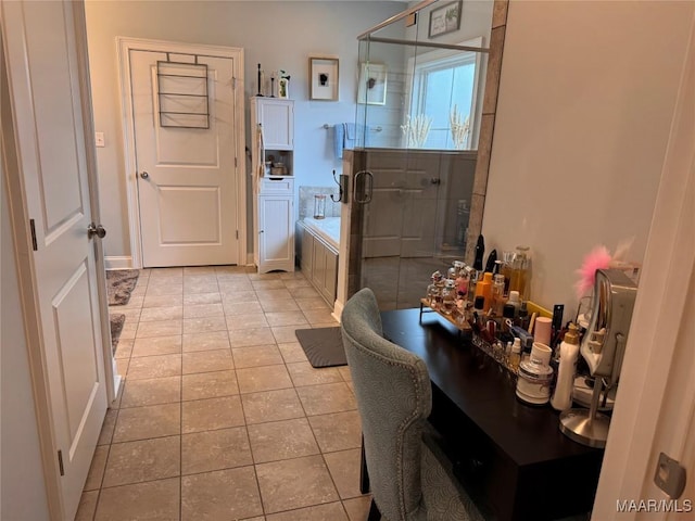 full bathroom with a stall shower, a washtub, and tile patterned floors