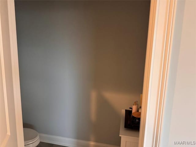 bathroom featuring toilet and baseboards