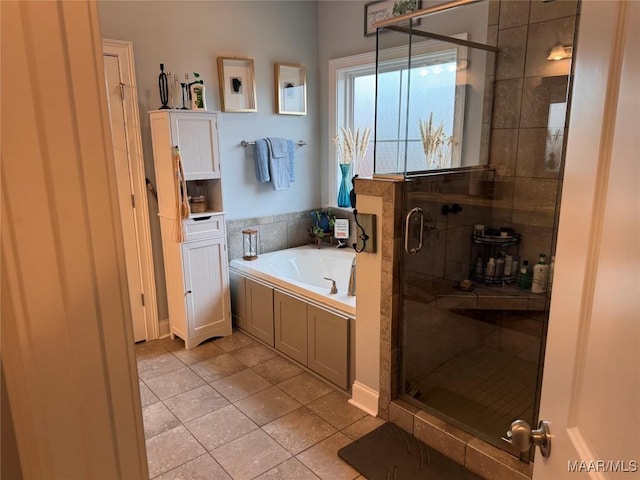 bathroom featuring a garden tub, a shower stall, and tile patterned floors