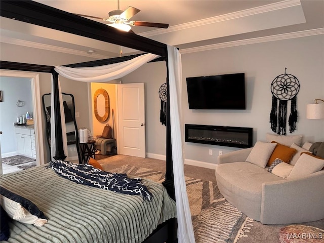 carpeted bedroom with ornamental molding, connected bathroom, a glass covered fireplace, and baseboards