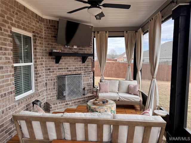 unfurnished sunroom with ceiling fan and an outdoor brick fireplace