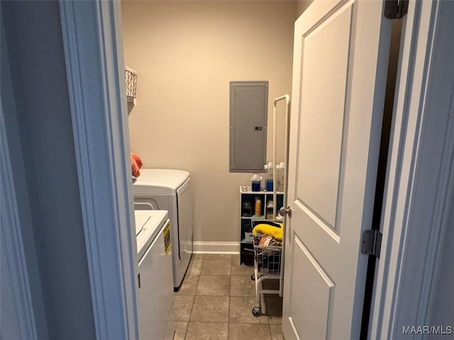 clothes washing area featuring laundry area, light tile patterned floors, electric panel, baseboards, and washing machine and clothes dryer