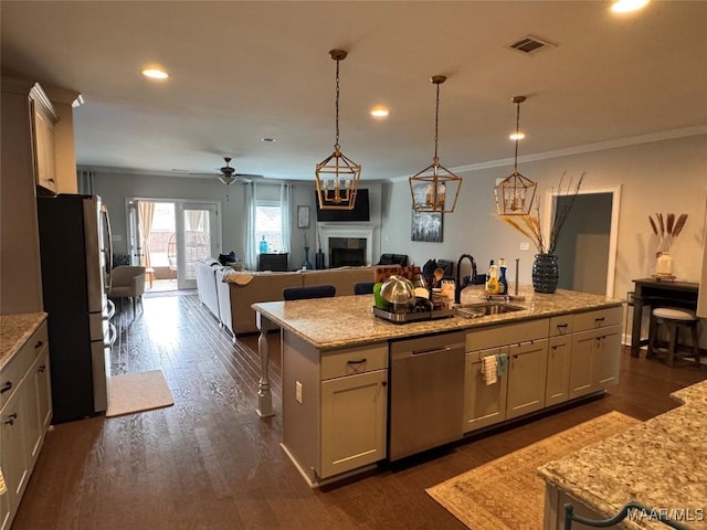 kitchen with a center island with sink, visible vents, appliances with stainless steel finishes, open floor plan, and a sink