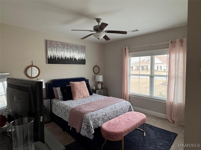 carpeted bedroom with visible vents, ceiling fan, and baseboards