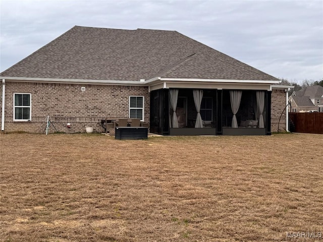 back of house featuring a sunroom, brick siding, and roof with shingles