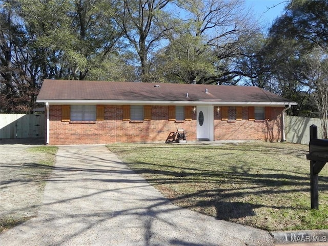 single story home with driveway, brick siding, a front yard, and fence