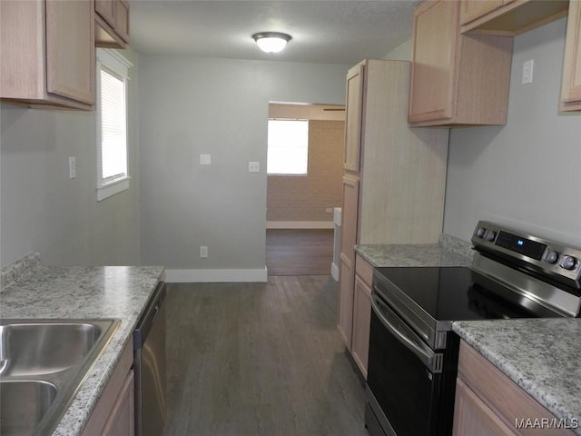 kitchen with baseboards, light countertops, appliances with stainless steel finishes, light brown cabinetry, and dark wood finished floors