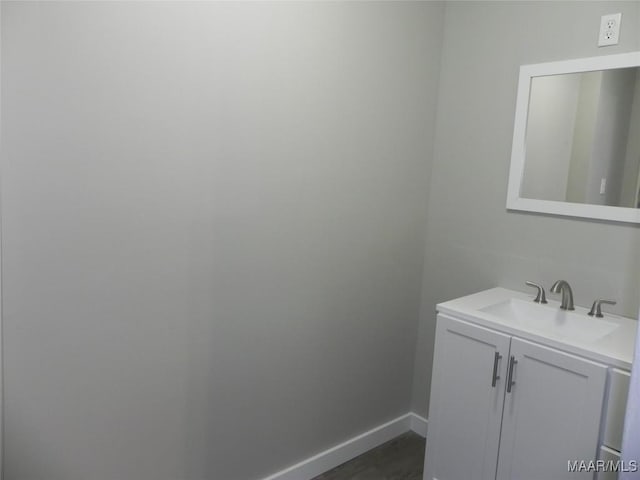 bathroom featuring wood finished floors, vanity, and baseboards