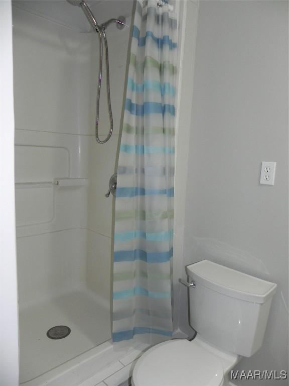 full bathroom with toilet and a shower stall